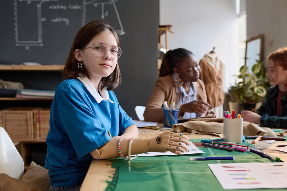 Side,view,portrait,of,teenage,girl,with,prosthetic,hand,drawing